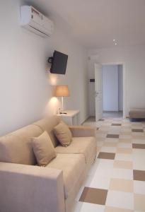 sala de estar con sofá y TV en Le Rose Beach & Suites appartamenti fronte mare a Villarosa, en Martinsicuro