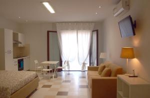 una camera con letto, divano e tavolo di Le Rose Beach & Suites appartamenti fronte mare a Villarosa a Martinsicuro