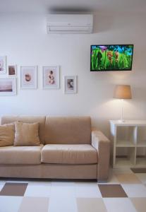 馬帝斯茲羅的住宿－Le Rose Beach & Suites appartamenti fronte mare a Villarosa，客厅配有沙发和墙上的电视
