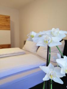 a bedroom with a bed with white flowers on it at Appartement Tauernlife in Schwarzach im Pongau