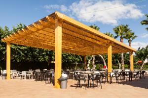 a large wooden pavilion with tables and chairs at Camping Platja Cambrils in Cambrils