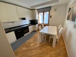 a kitchen with a white table and a table and chairs at Isabel in Pinzolo