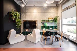 a dining room with a table and chairs and a tv at Apartamenty Depot Gdańsk in Gdańsk