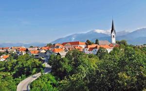 eine Stadt mit einer Kirche, einer Straße und Bäumen in der Unterkunft PR`Cajhn in Radovljica