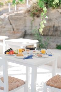 uma mesa branca com pratos de comida em Kostantakis Residence & Winery em Pollonia