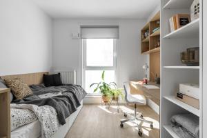 a bedroom with a bed and a desk and a chair at Apartamenty Depot Gdańsk in Gdańsk +57 photos