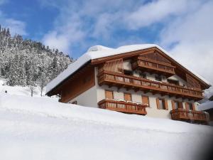 a building with snow on the side of it at Vista Pelmo in Colle Santa Lucia