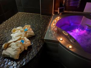 a bathroom with a purple tub with towels and lights at Sky Apartments Special in Strumica