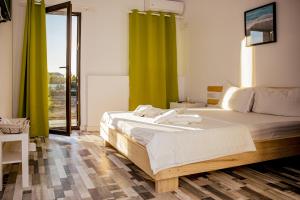 a bedroom with a large bed with green curtains at Happy In Vama Veche in Vama Veche +287 photos