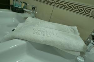 a white towel sitting on top of a sink at Rozafa Hotel in Shkodër
