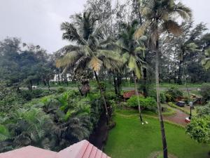 a view from the balcony of a resort with palm trees at SEAWOODS BEACH HOTEL in Dāhānu