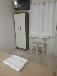 uma cozinha com armários brancos e duas toalhas no chão em Vista Oceanica Pousada em Marataízes
