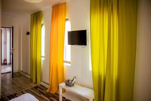 a room with colorful curtains and a tv on a wall at Happy In Vama Veche in Vama Veche