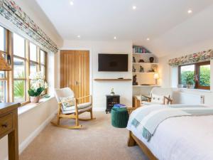 sypialnia z łóżkiem, biurkiem i krzesłami w obiekcie Bay Tree Cottage w mieście Droitwich
