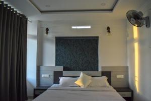 a bedroom with a large bed with a black headboard at Raveendra Inn in Kalpetta