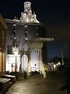 un bâtiment avec une tour d'horloge la nuit dans l'établissement Chez Bob, à Bovenkarspel