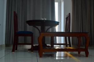 un tavolo e due sedie in soggiorno di Raveendra Inn a Kalpetta