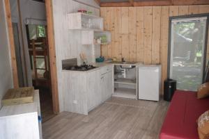 een keuken met een fornuis en een wastafel in de kamer bij Camping L'îlot du Chail in Sansais