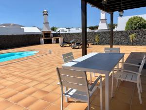 a patio with a table and chairs and a lighthouse at Casas Tomare I in San Bartolomé