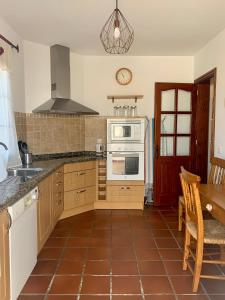 a kitchen with a stove and a microwave at Casas Tomare I in San Bartolomé