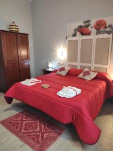 een groot rood bed met een rode deken erop bij B&B Babay in Guspini