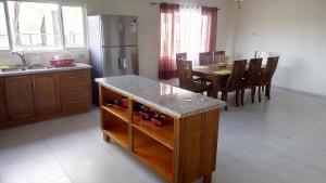 a kitchen and dining room with a table and a refrigerator at Michael's Tropical Suites in Scarborough