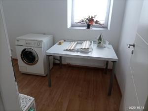 a laundry room with a table and a washing machine at Apartment O3 - Gehobene 6-Zimmer Wohnung 175qm für 1-7 Personen 2x DZ 3x EZ in Gravenwerth