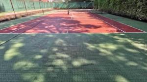 einen Tennisplatz mit Bäumen darüber in der Unterkunft Hotel Flóra** in Orosháza