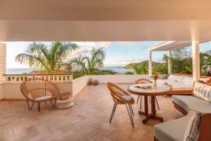 - un salon avec un canapé, une table et des chaises dans l'établissement Hôtel Barrière Le Carl Gustaf St Barth, à Gustavia