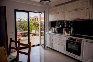 a kitchen with white cabinets and a door to a patio at Happy In Vama Veche in Vama Veche