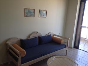 a living room with a blue couch and a table at Jason Hotel Apartments in Rethymno Town