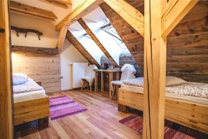 a room with two bunk beds and a table at Tourist Farm Šenkova Domačija in Zgornje Jezersko