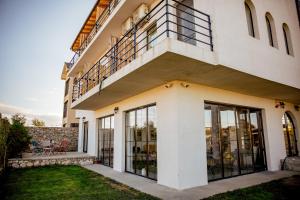 a building with glass doors and a balcony at Happy In Vama Veche in Vama Veche