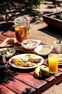una mesa de madera con platos de comida y bebidas. en Lebo's Soweto Backpackers, en Soweto