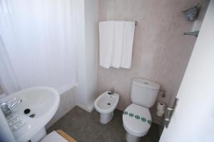 a white toilet sitting next to a white sink in a bathroom at Solvi Hotel in Vilanova i la Geltrú