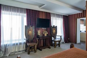 pokój hotelowy z łóżkiem i telewizorem w obiekcie Kodatskiy Kosh w mieście Dniepr