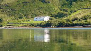 a house on a hill next to a body of water at Waterfront Rest B&B in Clifden