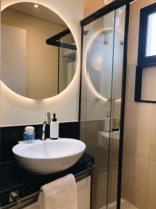 W łazience znajduje się umywalka oraz prysznic z lustrem. w obiekcie LOFT46 EM De MARILIA w mieście Marília