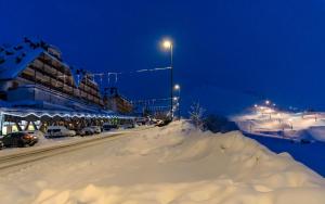 una pila de nieve al lado de una calle por la noche en Appartamenti i Portici, en Prato Nevoso