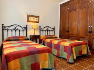 Casas Tomare II في سان بارتولومي: غرفة نوم مع سريرين مع بطانيات ملونة
