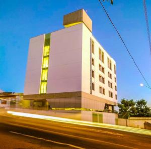 wysoki biały budynek z oświetleniem przed ulicą w obiekcie LOFT46 EM De MARILIA w mieście Marília