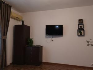 sala de estar con TV de pantalla plana en la pared en Coffee Residence, en Bucarest