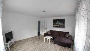 ein Wohnzimmer mit einem Sofa und einem TV in der Unterkunft Private and cozy Apartment in Refrath near Cologne in Bergisch Gladbach