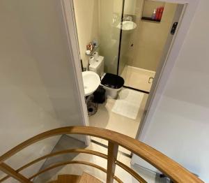 uma escada com uma casa de banho com um lavatório e um WC em LOFT46 EM De MARILIA em Marília