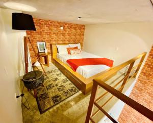 um quarto com uma cama e uma parede de tijolos em LOFT46 EM De MARILIA em Marília