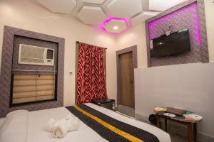 a bedroom with a bed and a tv on the wall at Snehamaya Spa & Resort in Digha