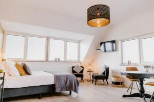 a bedroom with a bed and a table and chairs at Millsight in Uitgeest