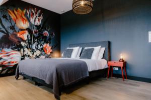 a bedroom with a large bed with a painting on the wall at Millsight in Uitgeest