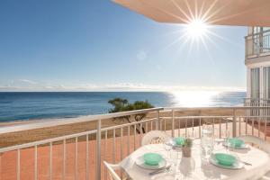 a table on a balcony with a view of the ocean at Hauzify I Apartament Cannes in Platja d'Aro