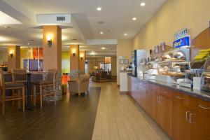 a restaurant with a counter and tables and chairs at Holiday Inn Express Hotel & Suites Prattville South, an IHG Hotel in Prattville